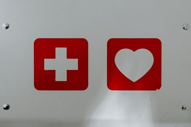 Rotes Kreuz-Symbol neben einem roten Herzsymbol auf weißem Hintergrund.