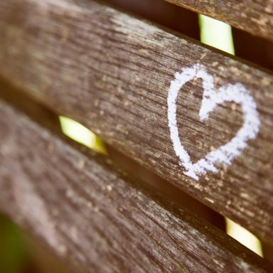 Herz.jpg Herz aus Kreide auf einer Holzbank, zwischen den Brettern sichtbar.